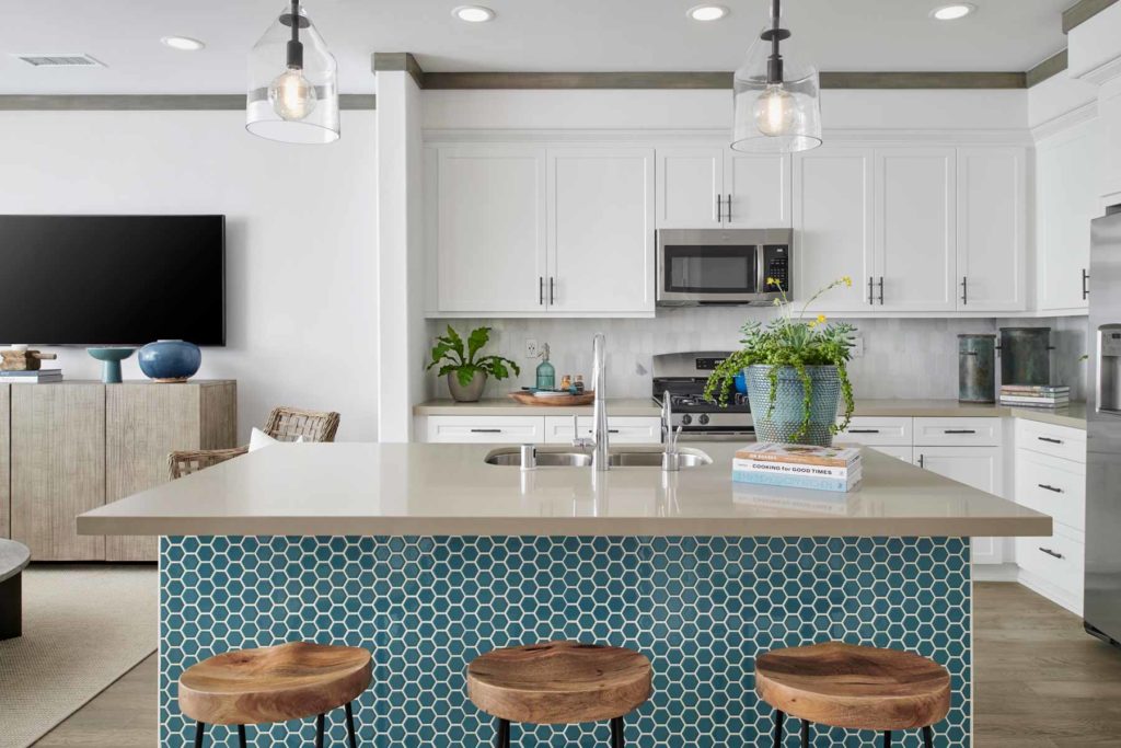 The kitchen island features a splash of ocean blue decorative tile that is as unexpected as it is beautiful.